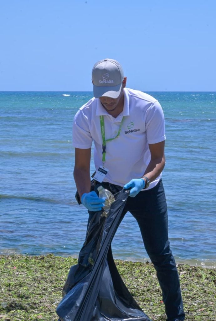 Colaborador de SeNaSa limpiando las playas