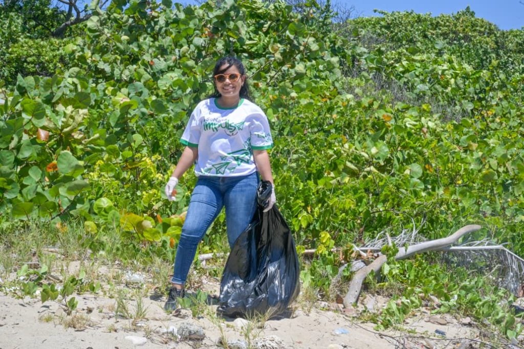 Colaboradora de SeNaSa limpiando las playas
